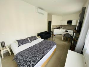 a bedroom with a large bed and a kitchen at Bordeaux cosy home in Bordeaux