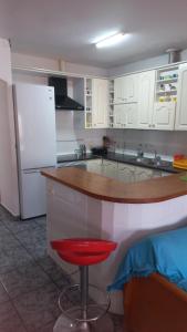 a kitchen with a counter and a red stool at Casacruz in Rodalquilar