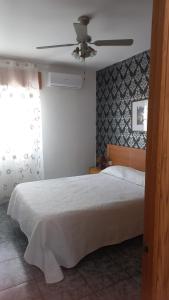 a bedroom with a bed and a ceiling fan at Casacruz in Rodalquilar +2 photos