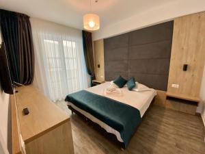 a bedroom with a bed and a large window at Apartament Ella C&C Residence in Mamaia Sat/Năvodari