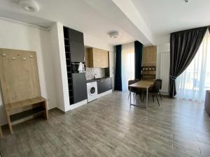 a living room with a table and a kitchen at Apartament Ella C&C Residence in Mamaia Sat/Năvodari