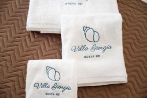 a group of white towels sitting on top of a bed at Villa Giorgia, graziosa villa a due passi dal mare in Costa Rei