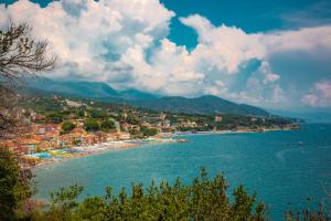 a view of a beach with buildings and mountains at Sea Point in Celle Ligure
