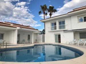a swimming pool in front of a villa at Residencial San Francisco in L'Eucaliptus