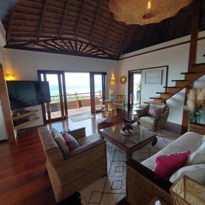un soggiorno con divani, tavolo e TV di 180 Degree Stunning Ocean Views in Entirely Equipped Villa! a Papetoai