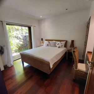 una camera da letto con un letto grande e una finestra di 180 Degree Stunning Ocean Views in Entirely Equipped Villa! a Papetoai