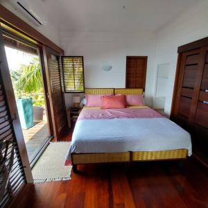 una camera da letto con un letto con cuscini rosa di 180 Degree Stunning Ocean Views in Entirely Equipped Villa! a Papetoai