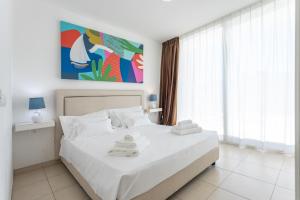 a bedroom with a white bed with towels on it at 19 Summer Suites in Santa Cesarea Terme