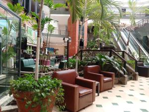 a lobby with chairs and palm trees in a building at EXECUTIVE SUITES VALENCIA in Valencia