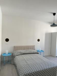 a bedroom with a bed with two blue tables at CYTRUS apartament in Marina di Massa