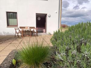 a patio with a table and chairs in front of a house at Apartment am Golfplatz in Obernkirchen