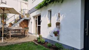 a white house with a table and an umbrella at Charmantes Quartier im Herzen der Altstadt in Mönchengladbach