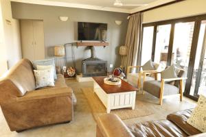 ein Wohnzimmer mit Couch und Kamin in der Unterkunft Shiloh Cottage in Champagne Valley