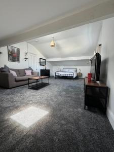 a living room with a couch and a bed at The Eaves - Victorian second floor, open plan apartment in Southport