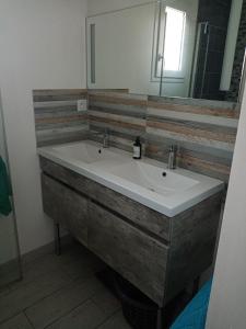 ein Badezimmer mit Waschbecken und Spiegel in der Unterkunft location bord de mer La Plaine sur mer in La Plaine-sur-Mer