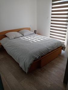 Schlafzimmer mit einem Bett mit einem Holzrahmen und einem Fenster in der Unterkunft location bord de mer La Plaine sur mer in La Plaine-sur-Mer