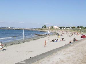 eine Gruppe von Menschen sitzt an einem Strand in der Unterkunft location bord de mer La Plaine sur mer in La Plaine-sur-Mer