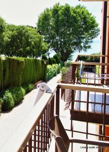 a balcony of a building with trees and a walkway at Appartamento con spiaggia privata vista lago nuovissimo in Bardolino