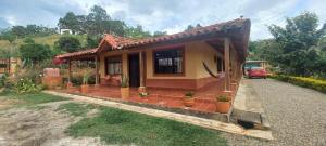 a small house with a car parked in front of it at CASA CAMPESTRE Villa Carolina in San Gil