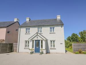 una casa blanca con una puerta azul en Cysgod Y Garn, en Newport