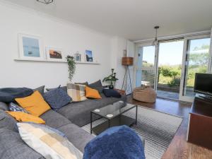 sala de estar con sofá gris y almohadas amarillas en Cysgod Y Garn, en Newport