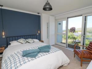 Un dormitorio con una cama con una pared de acento azul en Cysgod Y Garn, en Newport
