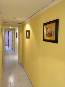 a hallway with yellow walls and a picture on the wall at La Rose in Gandía