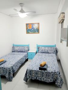 a bedroom with two beds and a painting on the wall at La Rose in Gandía