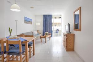 un salon avec une table à manger et une télévision dans l'établissement Apartamento Estándar 2, à Colonia Sant Jordi