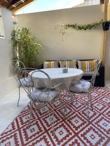 a white table and chairs on a red and white rug at Charmante maison de ville in Mirepoix