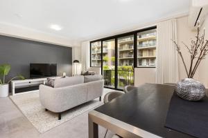 a living room with a couch and a table at 1BR Stylish Suite on Hay St in Perth
