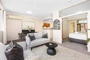 a living room with a couch and a bed at 1BR Stylish Suite on Hay St in Perth