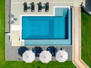 an overhead view of a swimming pool with umbrellas at Greenheart - Mediterranean Elegance in Nature in Ialyssos