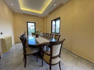 a dining room with a wooden table and chairs at Batroun Green Serenity 2 BED - 24hr Electricity in Batroûn