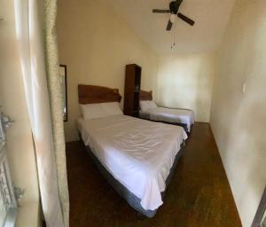 a bedroom with two beds and a ceiling fan at Casa Piedra de Agua Bacalar in Bacalar