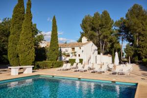 a villa with a swimming pool in front of a house at VILASIRA ( Rooms & Wines ) in Los Cojos
