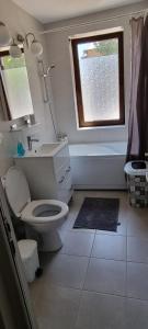 un bagno con un water, un lavandino e una finestra di Studio Sat Vacanta Free parking a Constanţa