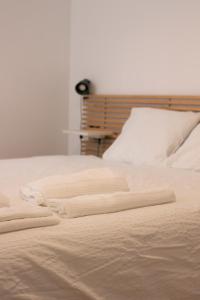a white bed with two folded towels on it at Barcelona a 20 minutos en piso reformado y soleado in Gavà +13 photos