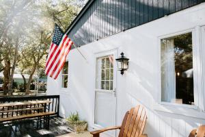 una bandera estadounidense en el costado de una casa blanca en Cottage by the Sea: Pagnotto Shellback House, en Oak Island