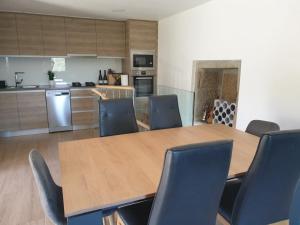 a kitchen with a wooden table and chairs at A Nossa Casinha in Arcos de Valdevez