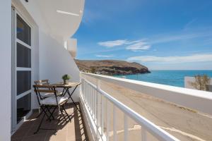 ein Balkon mit Tisch und Blick auf das Meer in der Unterkunft La Lajita Barca Beach Sunset in Lajita