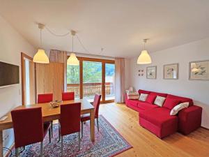 Una sala de estar con un sofá rojo y una mesa. en Haus Margaret By Globalimmoservice, en Bad Kleinkirchheim