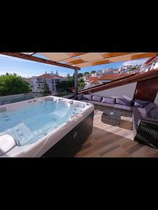 a large hot tub on a balcony with chairs at Penthouse Stella in Pula