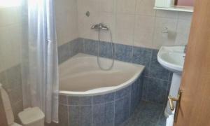 a bathroom with a bath tub and a sink at Ionian Balcony in Lixouri