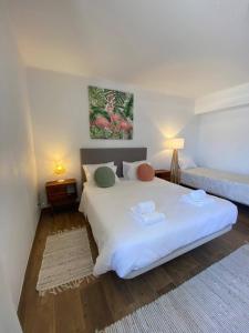 a bedroom with a large white bed with two pillows at Casa Pavão in Pilar