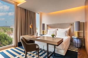 a hotel room with a bed and a desk and a window at Palácio do Governador - Lisbon Hotel & Spa in Lisbon