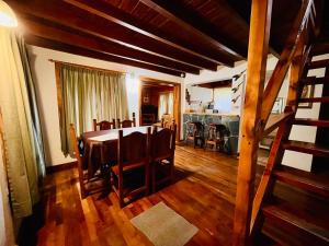 ein Esszimmer und eine Küche mit Tisch und Stühlen in der Unterkunft Cuncumen Casa de Montaña in Villa La Angostura