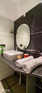a bathroom with a sink and a mirror at Saanvi Farmhouse in Hampi