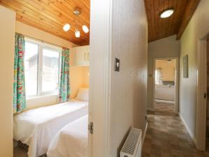 a bedroom with two beds and a window at Lodge 16 in Torpoint +20 photos