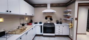 una cucina con mobili bianchi e un forno a piano cottura di Allianz Parque, piscina, churrasqueira e dois shoppings centers a San Paolo Altre 30 foto